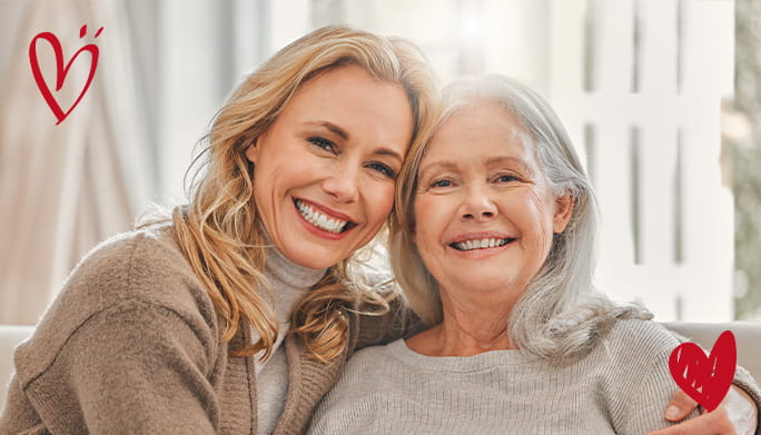 Mother and daughter hugging and smiling at camera